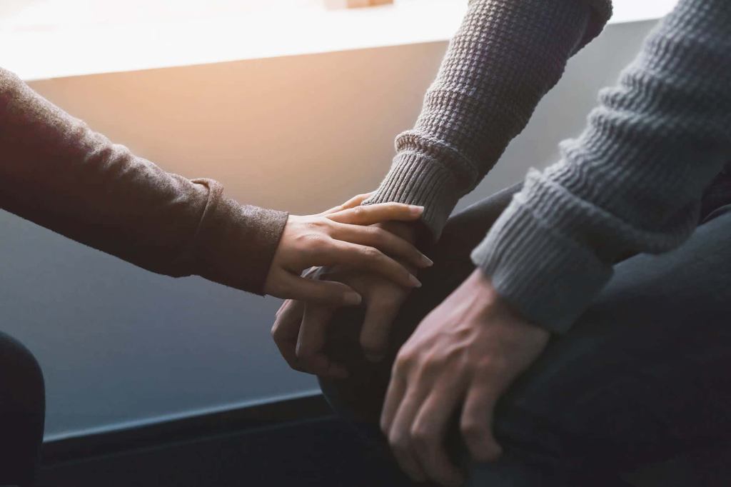 Man suffering from PTSD while loved one comforts them