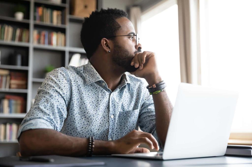 man at laptop looking off into the distance